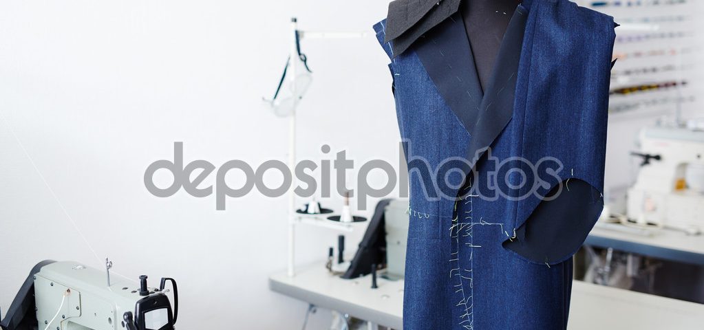 Unfinished jacket and trousers on mannequin in tailor workshop